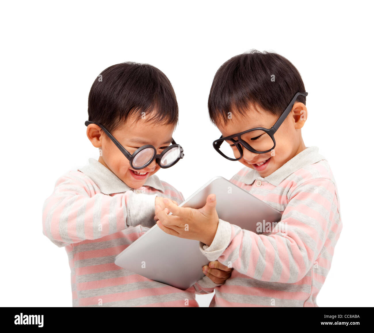 Deux enfants heureux à l'aide de l'ordinateur tablette tactile et isolated on white Banque D'Images