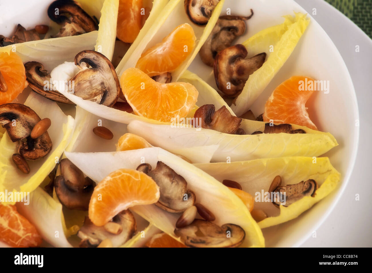 Salade de chicorée avec mandarines, les champignons et les noix de pin Banque D'Images