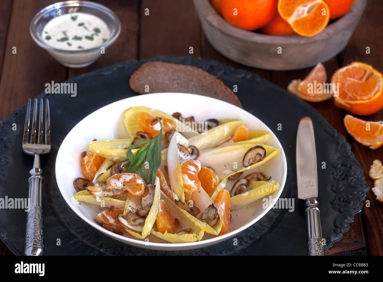 Salade de chicorée avec mandarines, les champignons et les noix de pin Banque D'Images