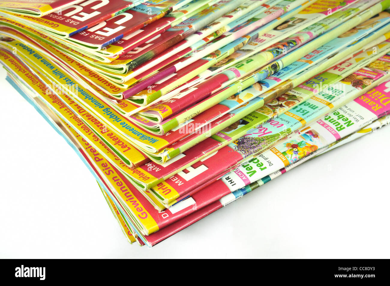 Pile de magazines multicolores sur fond blanc Banque D'Images