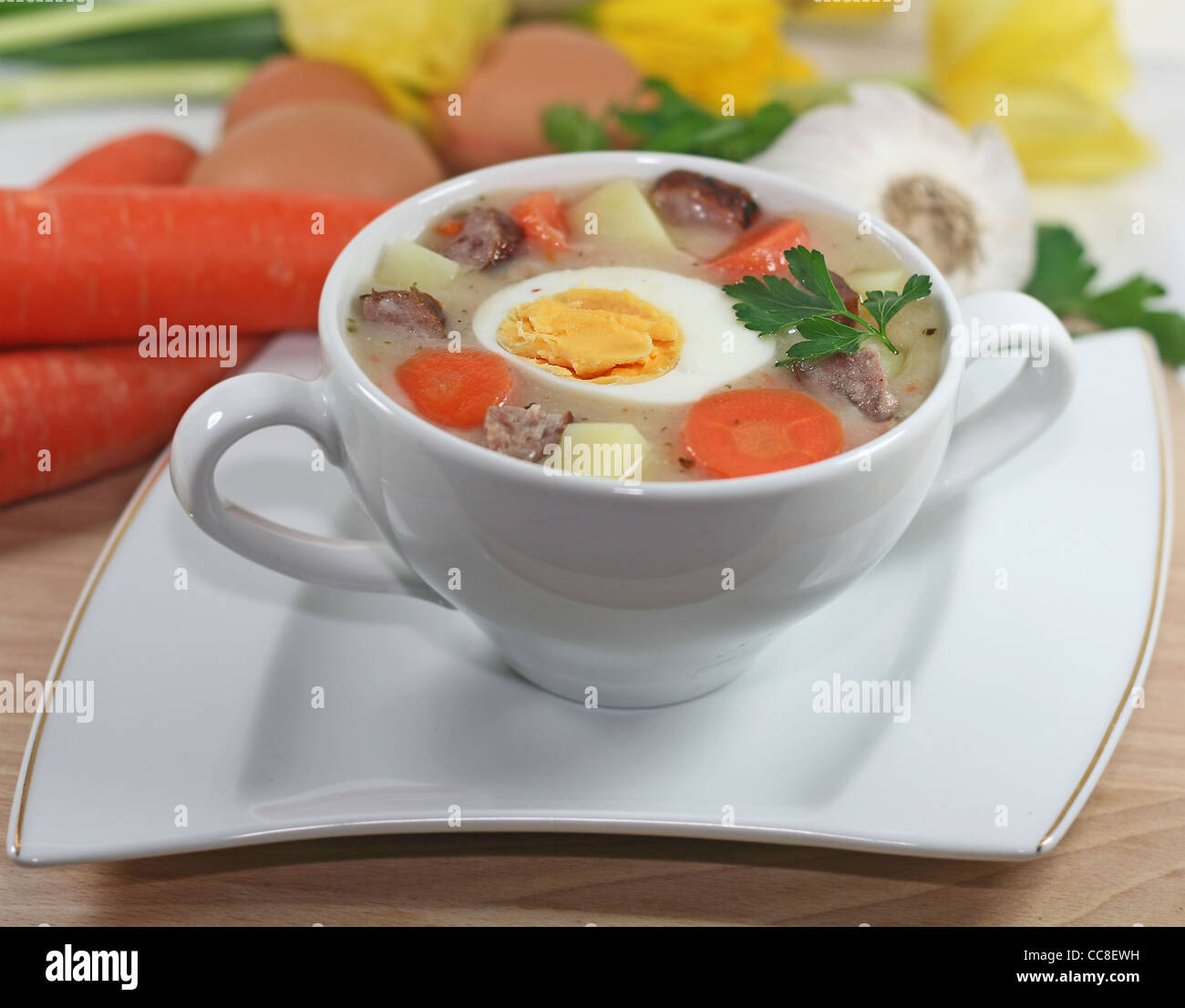 Bortsch blanc polonais traditionnel avec des œufs et des saucisses en vaisselle blanche pour Pâques Banque D'Images