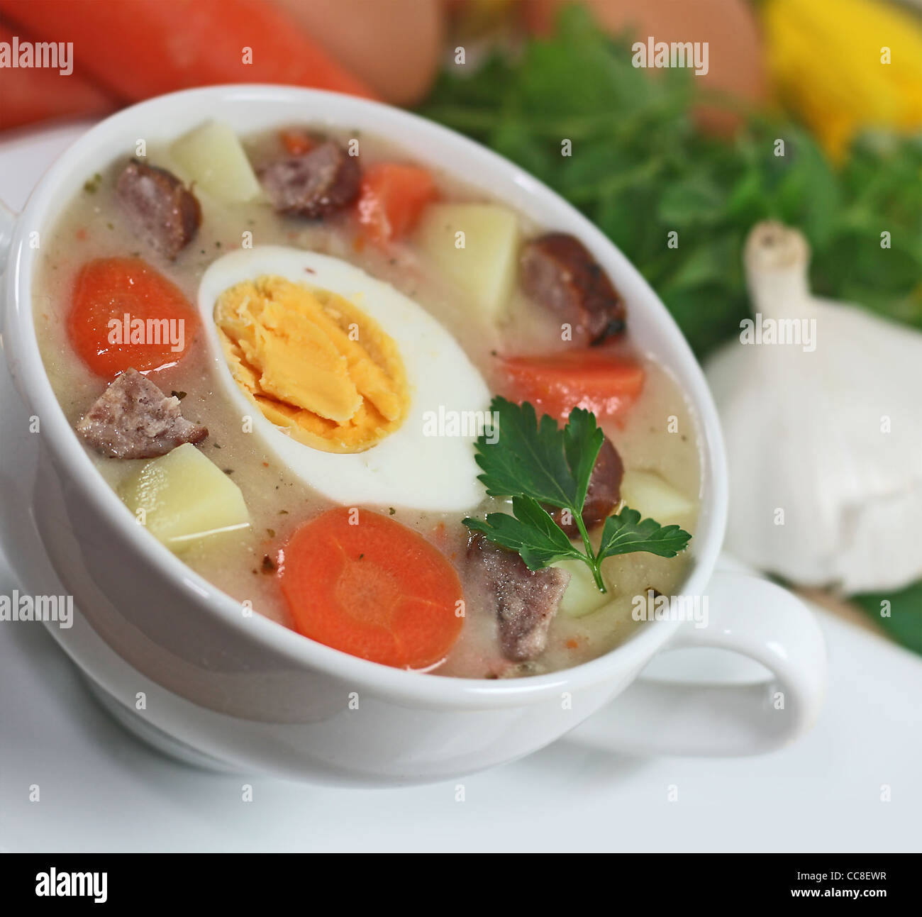 Bortsch blanc polonais traditionnel avec des œufs et des saucisses en vaisselle blanche pour Pâques Banque D'Images