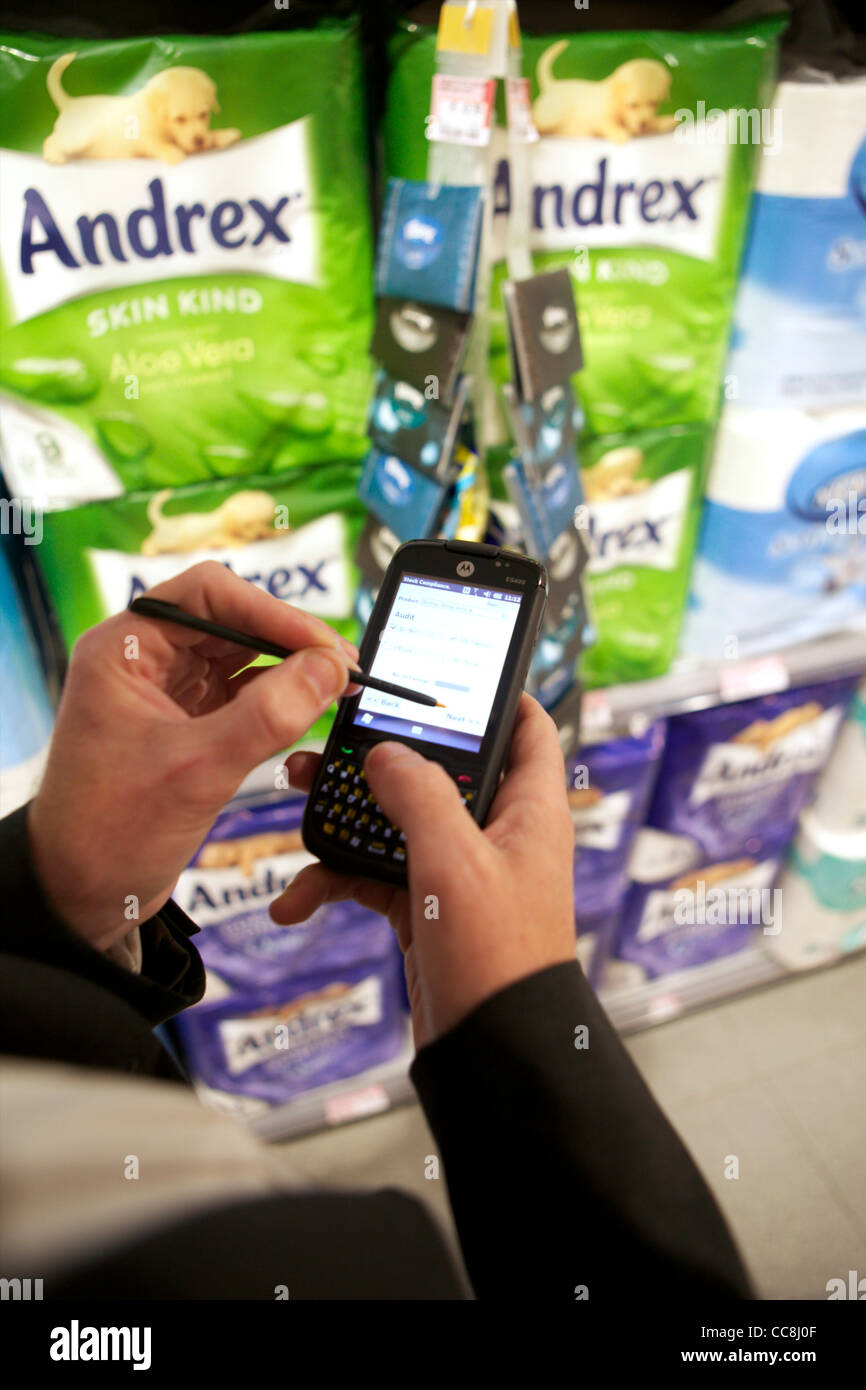 Un ordinateur de poche faisant une vérification en magasin sur les produits en vente Banque D'Images