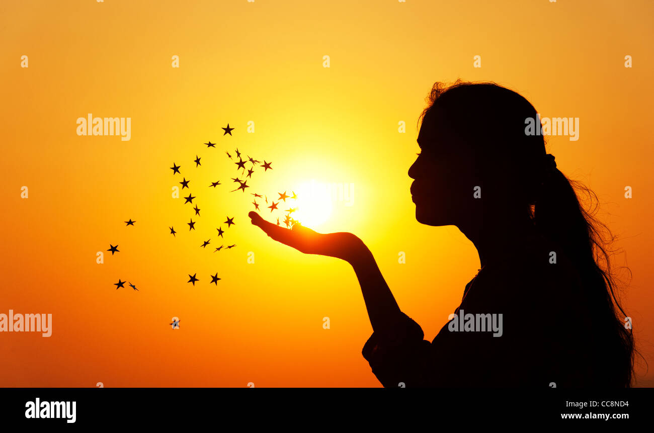 Indian girl blowing stars dans l'air. Silhouette. L'Inde Banque D'Images