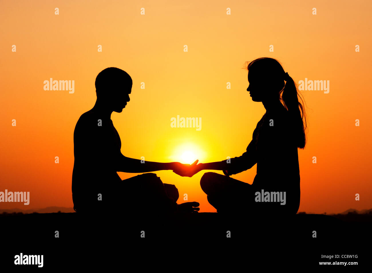 L'homme Indien et indian girl holding le soleil. Silhouette. L'Inde Banque D'Images