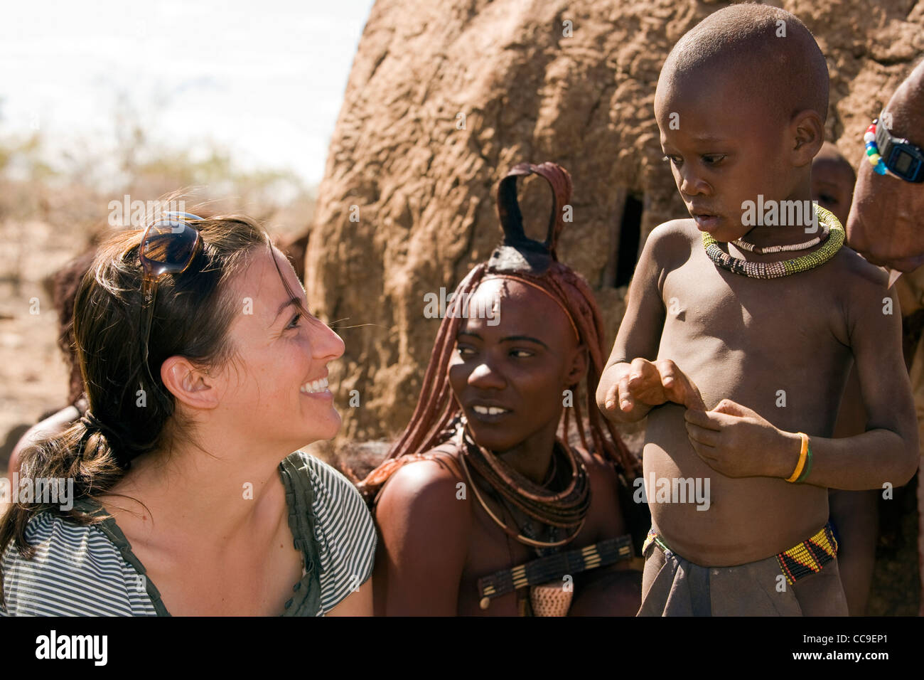 Jeune femme en interaction avec l'enfant Himba - Orupembe Conservancy - Kaokoland, Namibie Banque D'Images