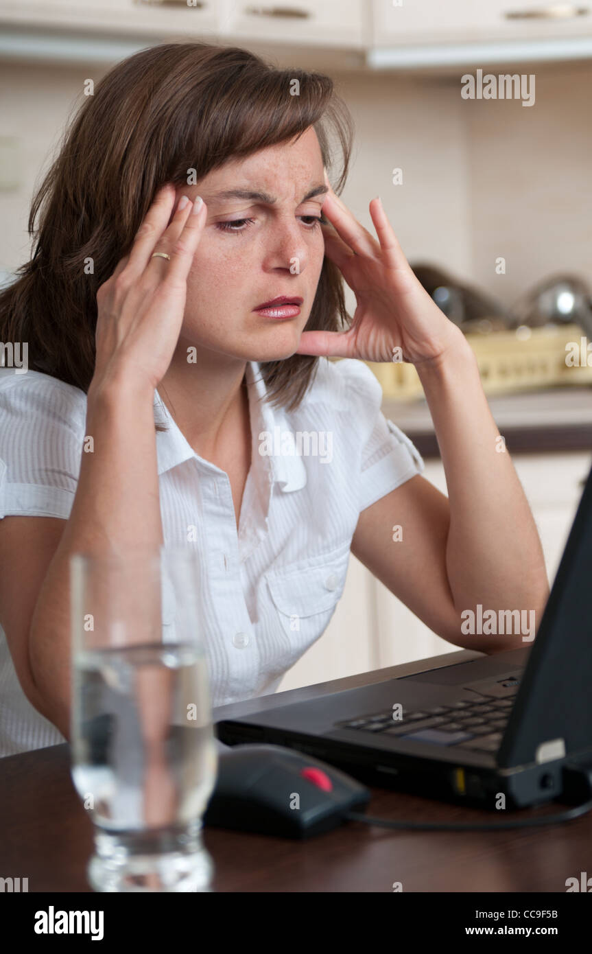 Business Woman avec maux de travailler à domicile Banque D'Images
