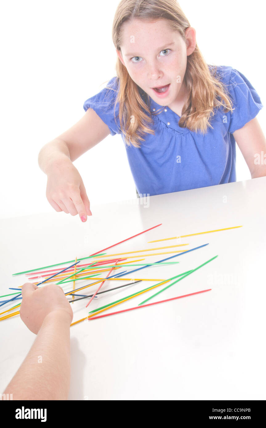 Les enfants jouent le jeu de pick up sticks Banque D'Images