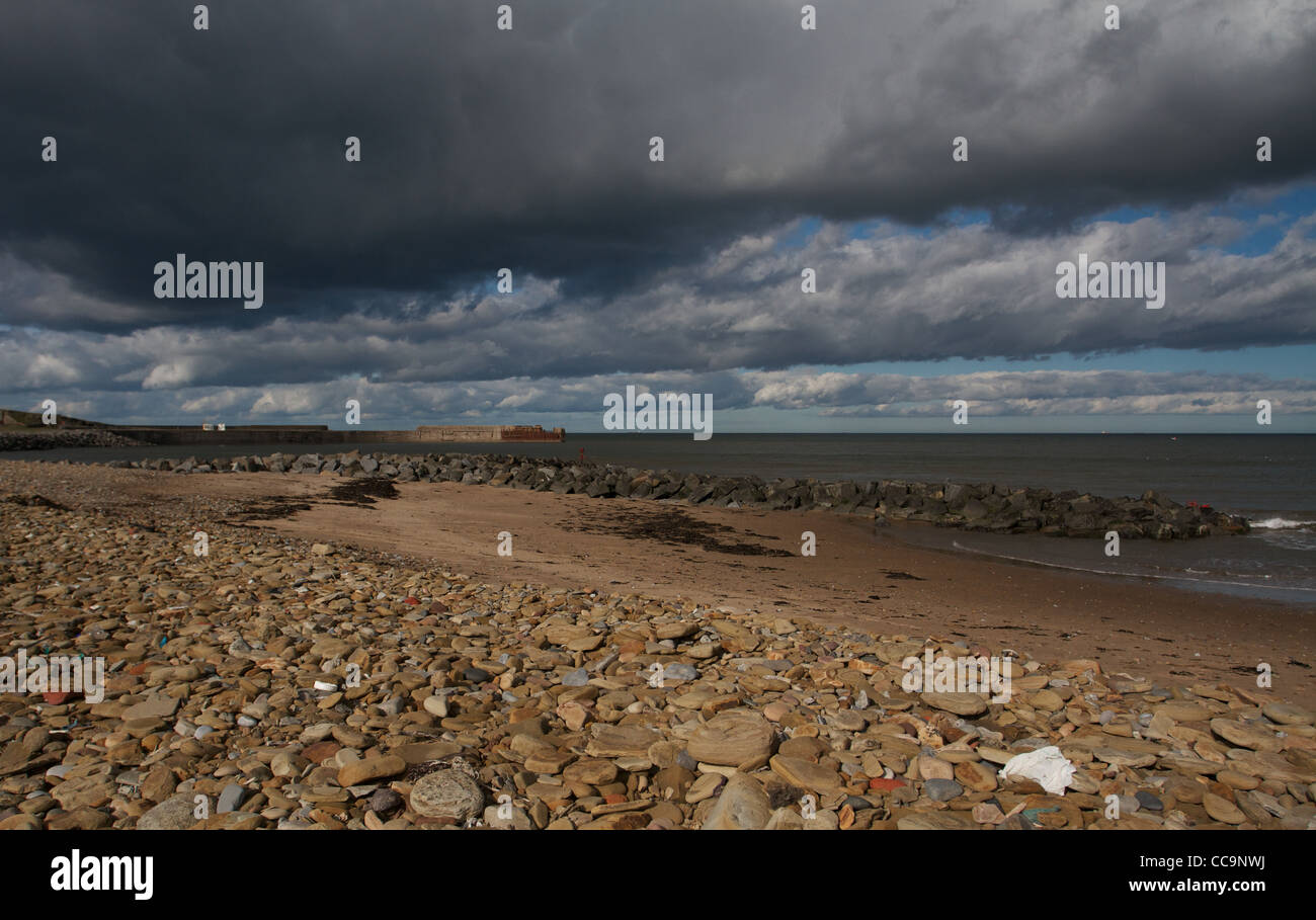 Vue panoramique sur la plage et jetée Skinningrove sous un ciel d'orage Banque D'Images