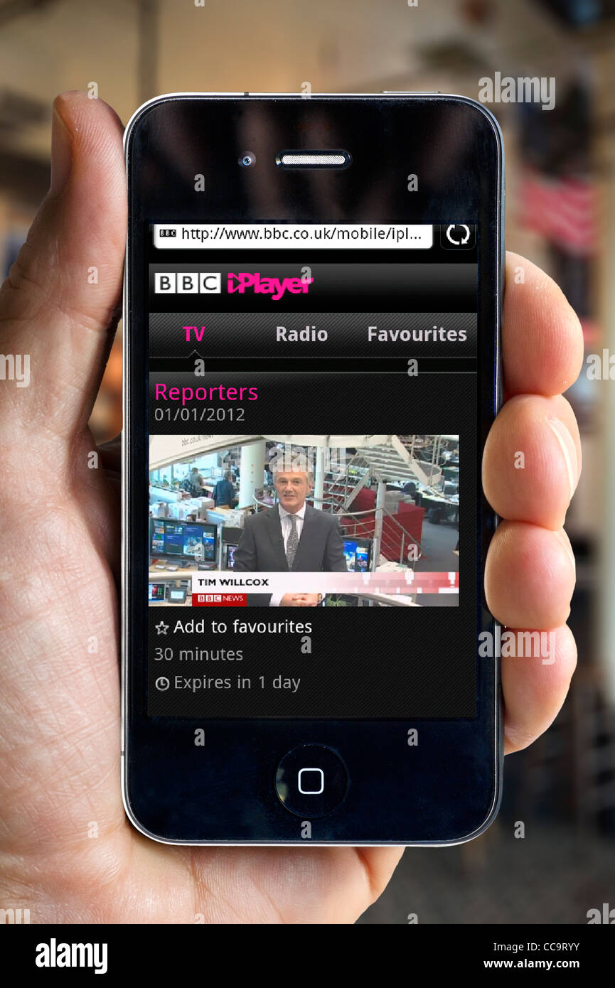 Regarder la BBC News Channel sur le BBC iPlayer sur un smartphone Apple iPhone 4 via un hotspot Wi-Fi public Banque D'Images