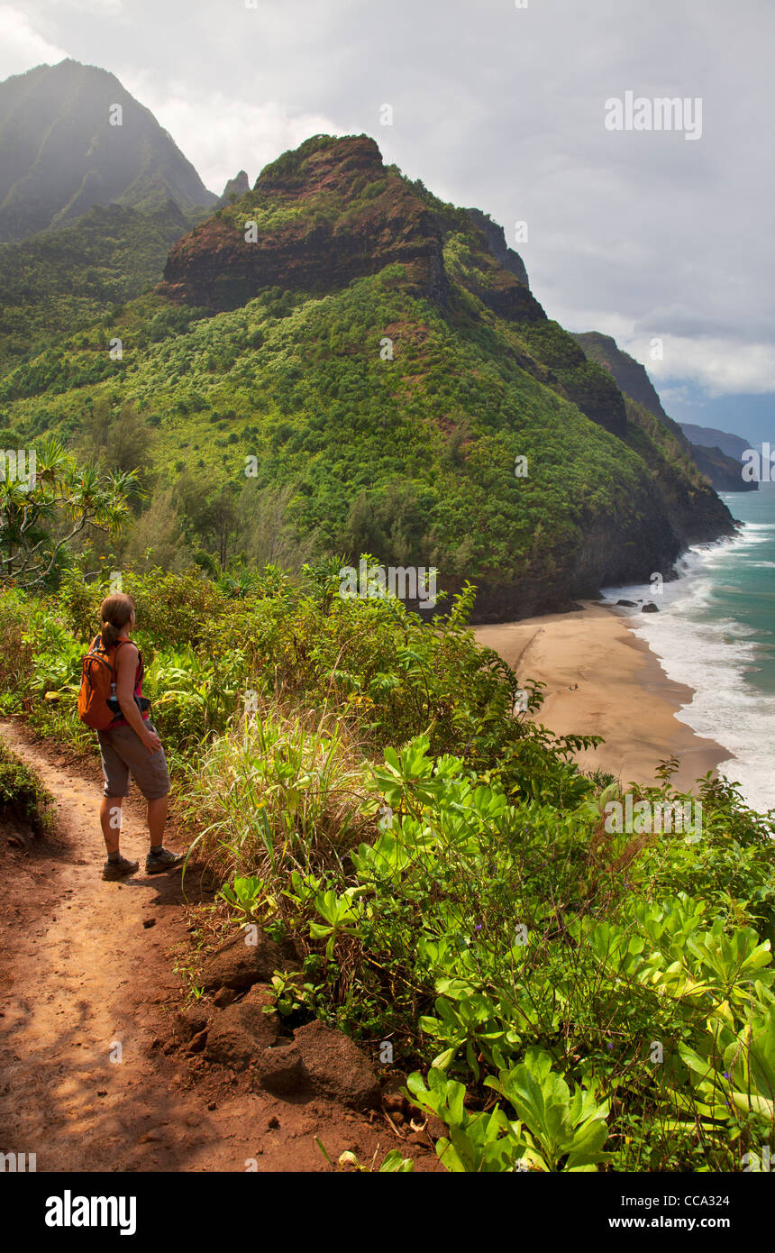 Randonneur donne sur la côte de Na Pali du Kalalau Trail près de Hanakapi'ai Beach, Kauai, Hawaï. (Modèle 1992) Banque D'Images