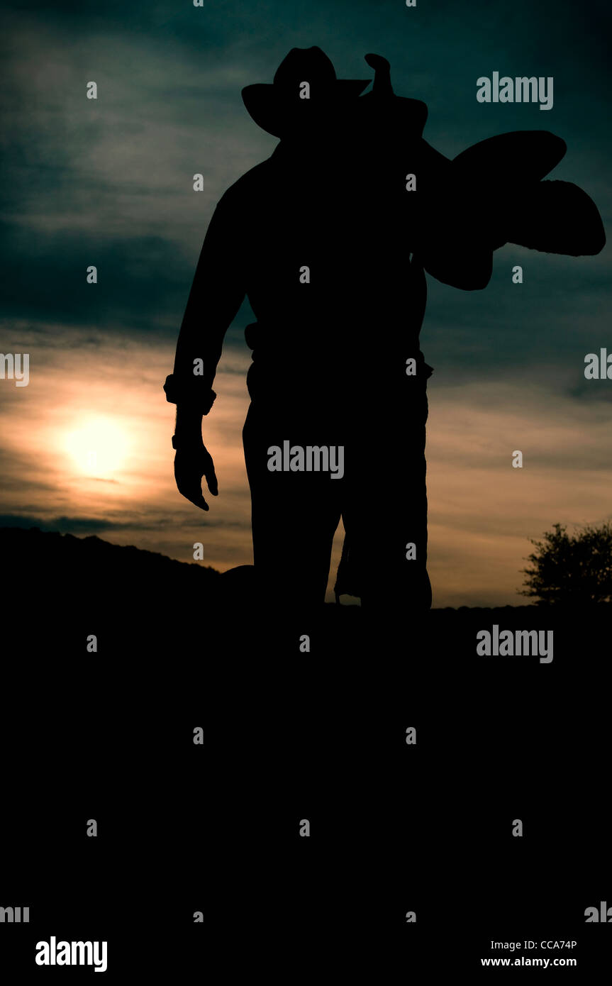 Working Man silhouette au coucher du soleil - l'appeler un jour de Cowboy Banque D'Images