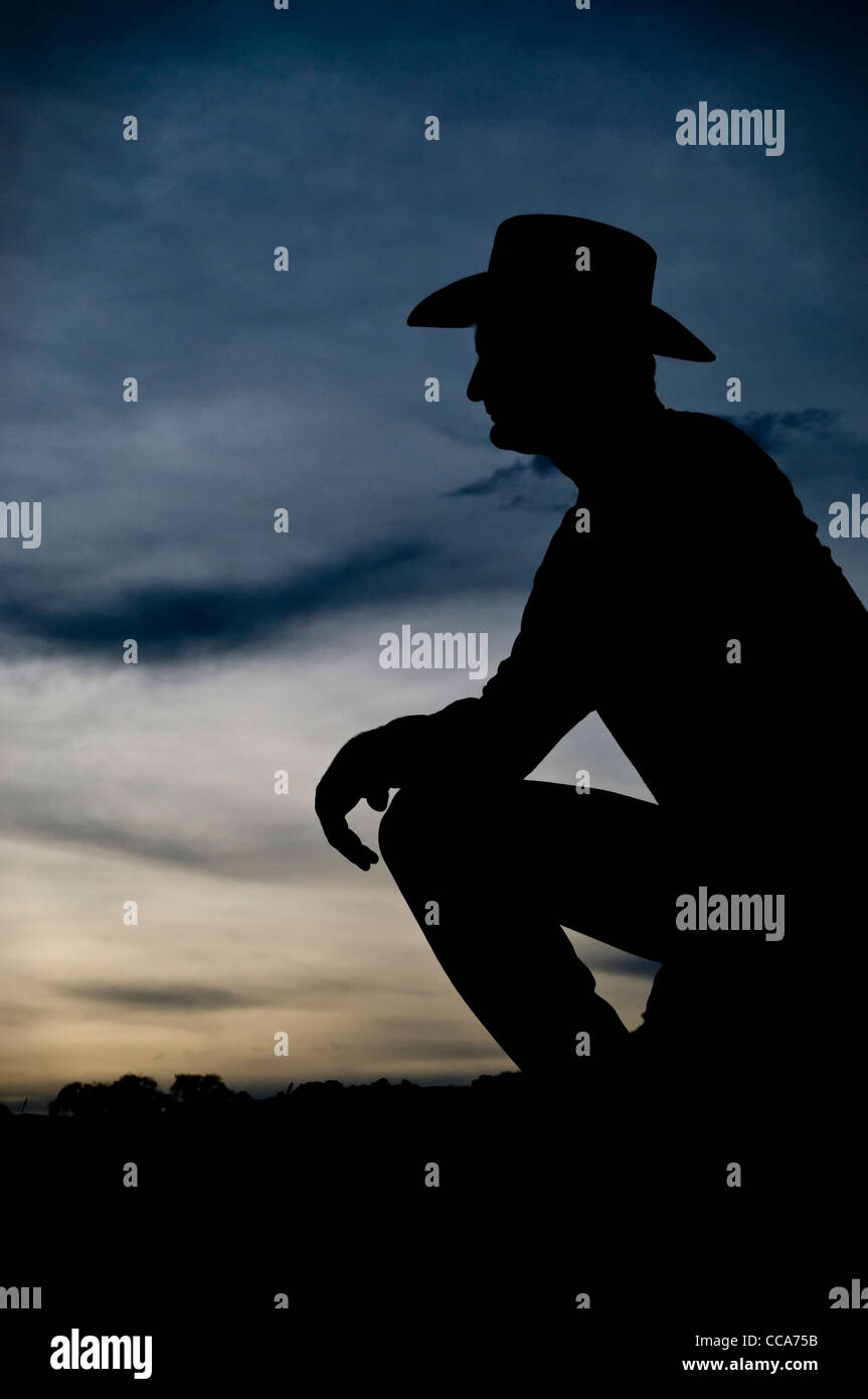 Silhouette de cow-boy au coucher du soleil Banque D'Images
