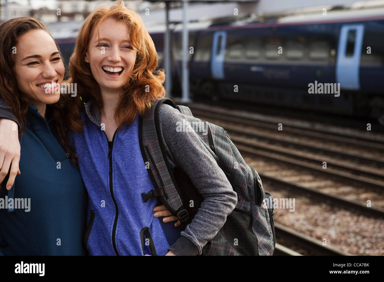 Young women smiling at train station Banque D'Images