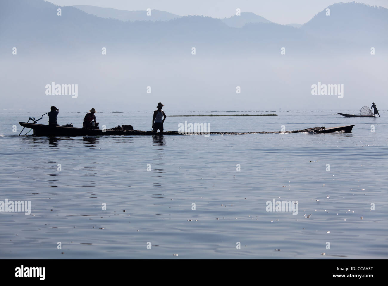 Haunting pêcheur tribal sur le lac Inle en Birmanie. Technique unique de jambe d'aviron et conique résille. Banque D'Images