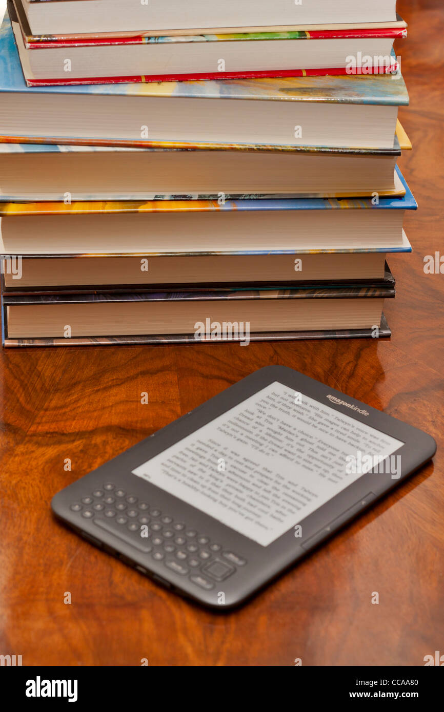Amazon Kindle à côté d'une pile de livres Banque D'Images