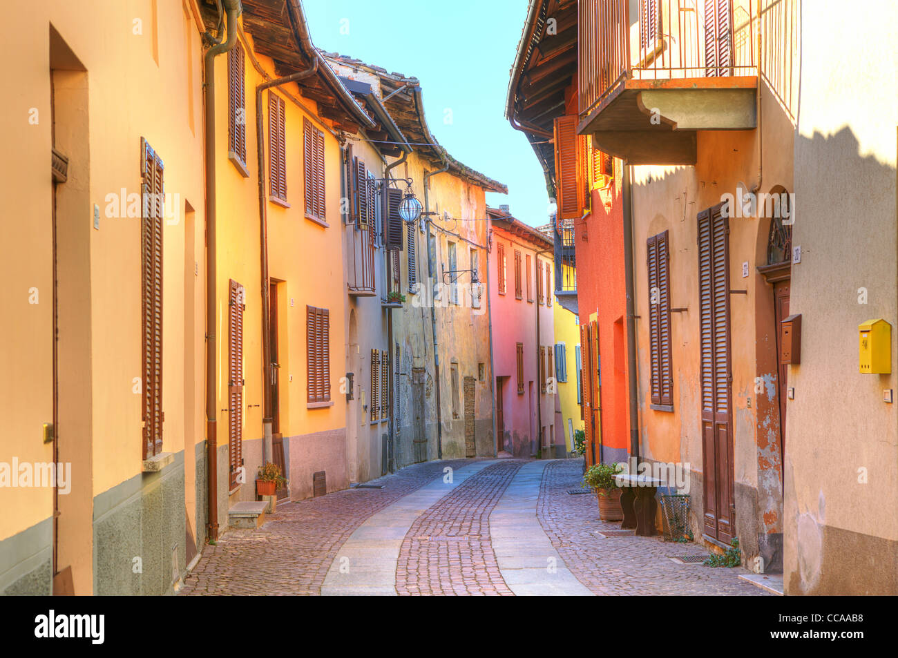 Rue étroite pavée parmi les vieux maisons multicolores de la ville de Serralunga D'Alba dans le Piémont, Italie du Nord. Banque D'Images
