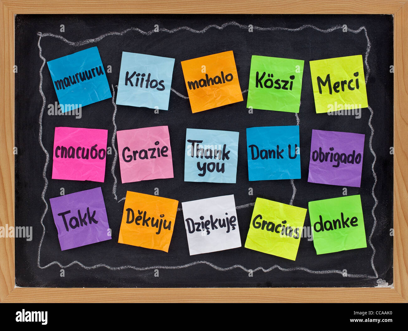 Merci en 16 langues - des notes adhésives sur tableau noir avec craie blanche taches Banque D'Images