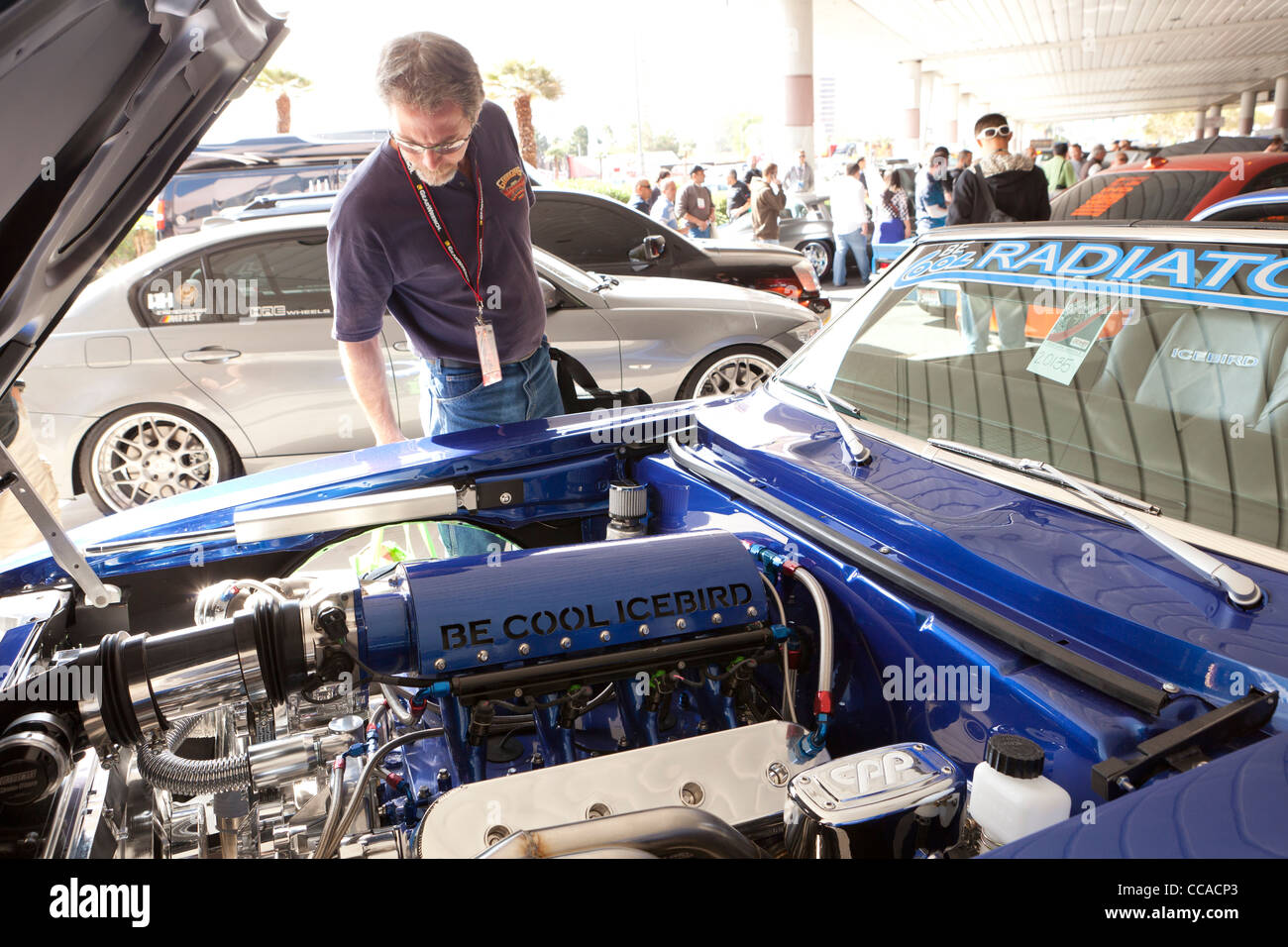 Un amateur de voiture de l'inspection d'un hot rod à moteur car show Banque D'Images
