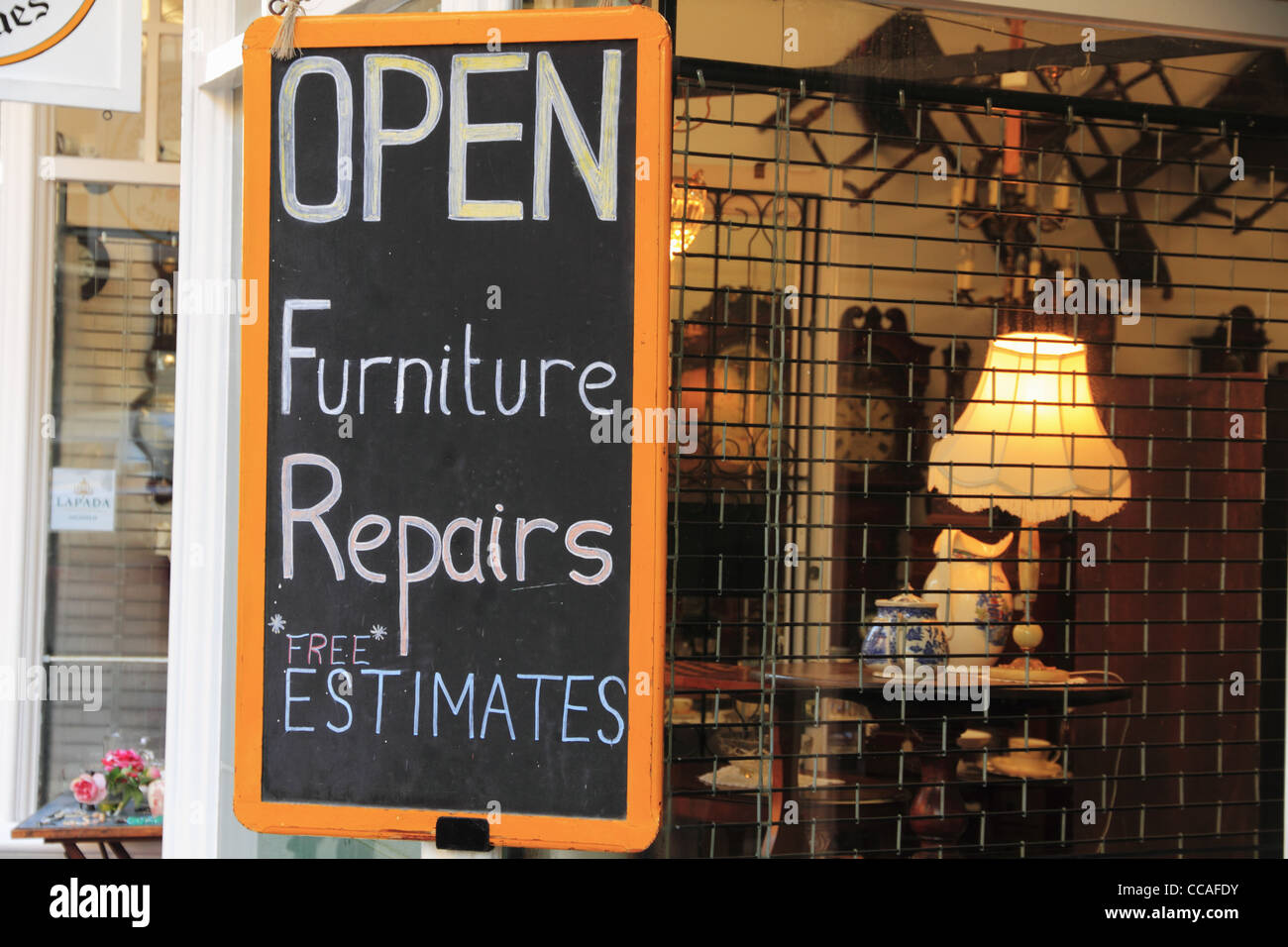 Inscrivez-vous publicité réparation de meubles réparation et devis gratuits dans un magasin d'antiquités de fenêtre. Banque D'Images
