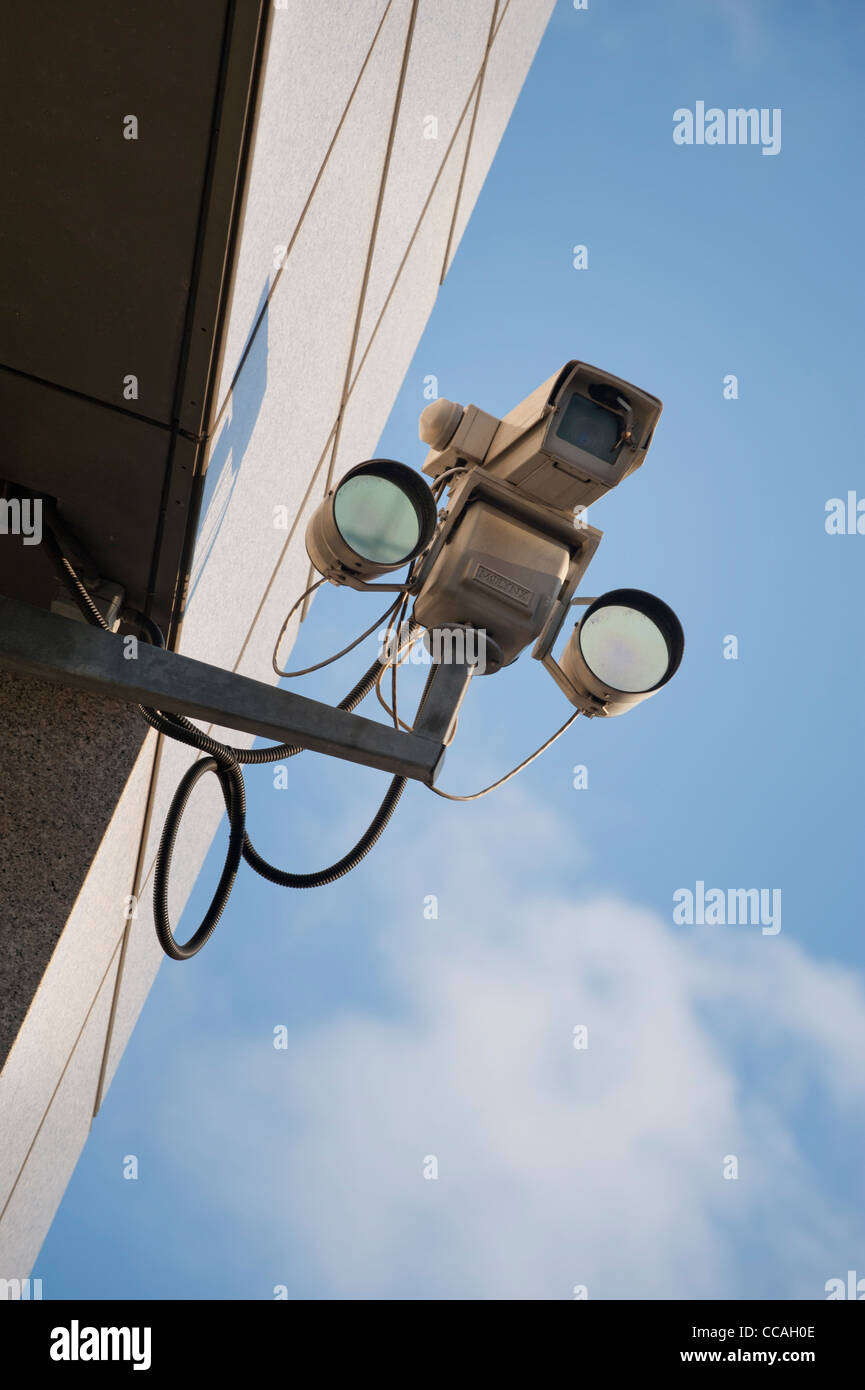 Une caméra de surveillance reliée à un bâtiment sur un ciel clair et lumineux 24. Banque D'Images