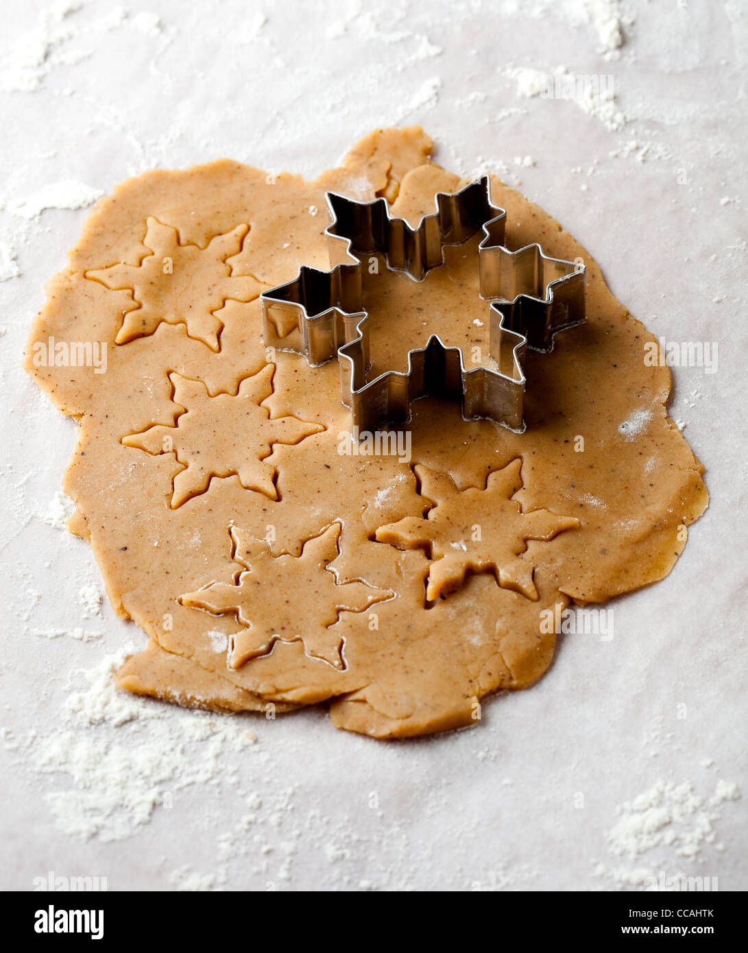 Making gingerbread cookies pour Noël. Pâte d'épices avec des étoiles de formes et d'un cutter. Banque D'Images