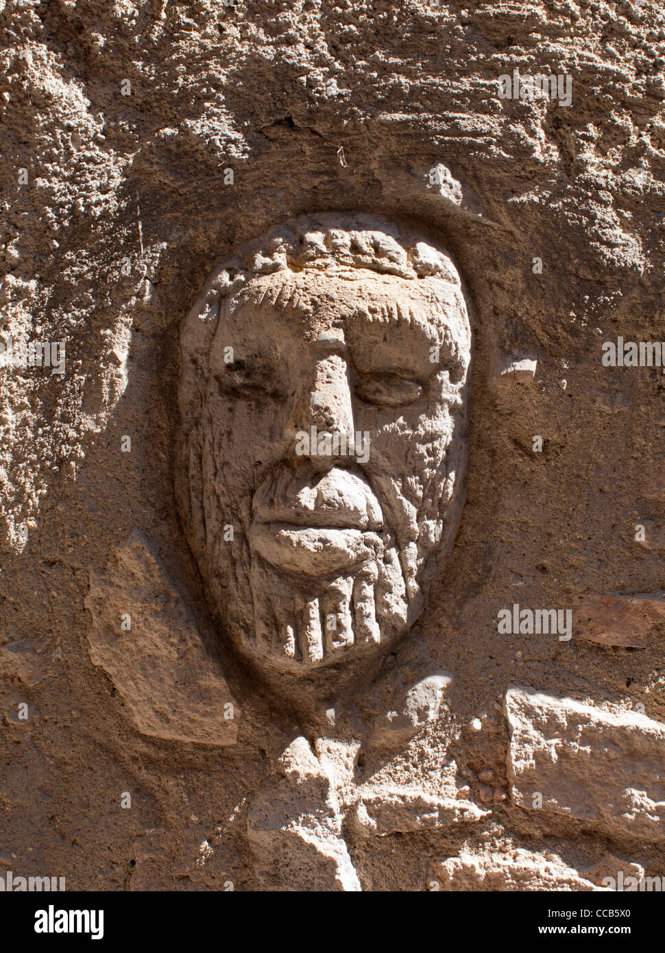 Un visage humain sculpté dans un mur. Bolsena, Italie. Banque D'Images