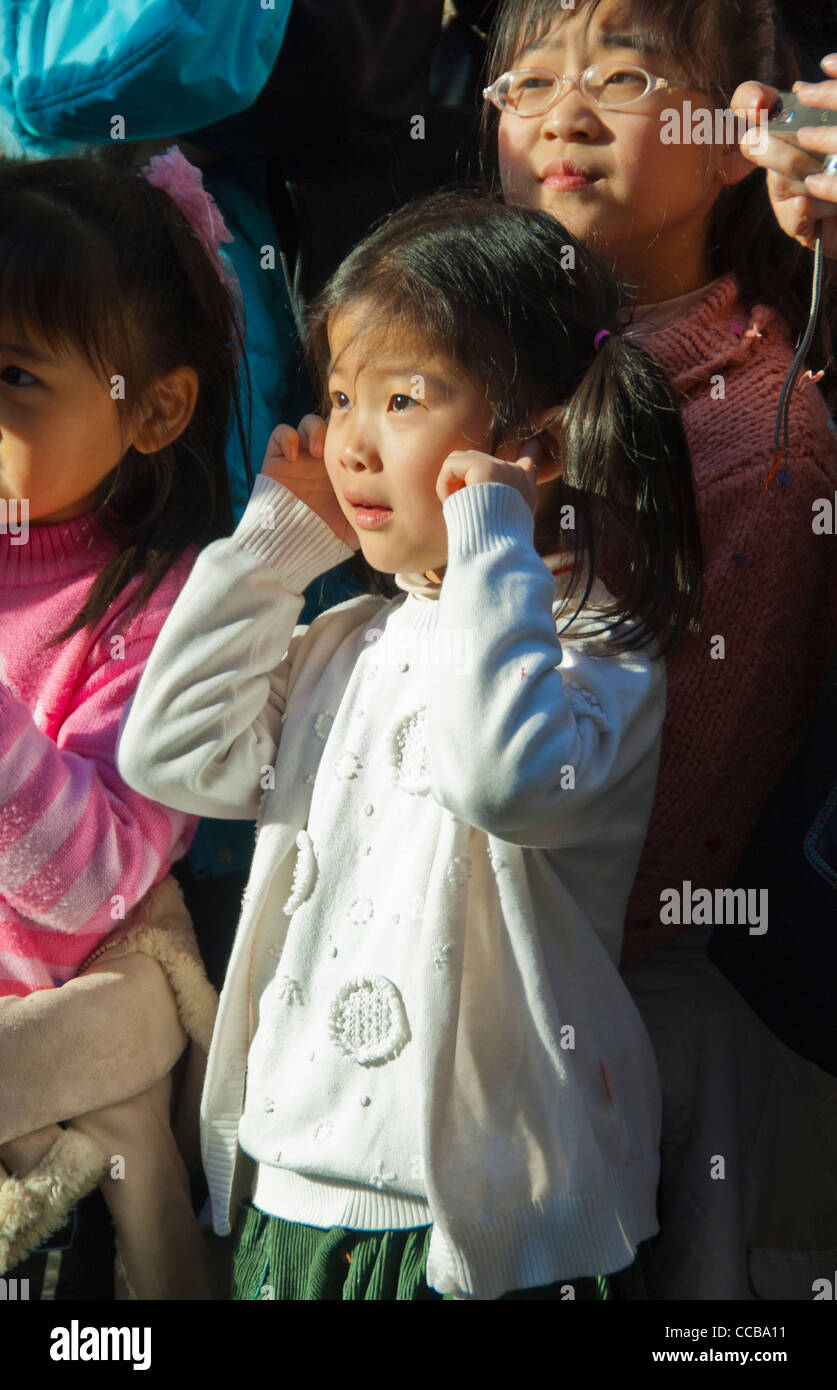 Paris, France, l'enfant tenant une femme chinoise, bruit oreilles regardant défilé, nouvel an chinois carnaval de rue dans le quartier du Marais, de pétards Banque D'Images