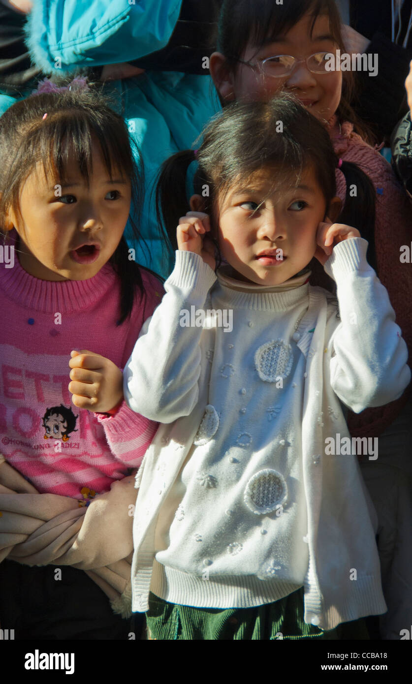 Paris, France, l'enfant tenant une femme chinoise, bruit oreilles regardant défilé, nouvel an chinois carnaval de rue dans le quartier du Marais, de pétards Banque D'Images