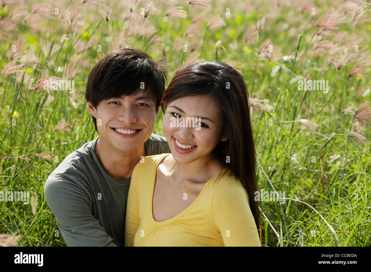 Smiling couple extérieur in grassy field Banque D'Images