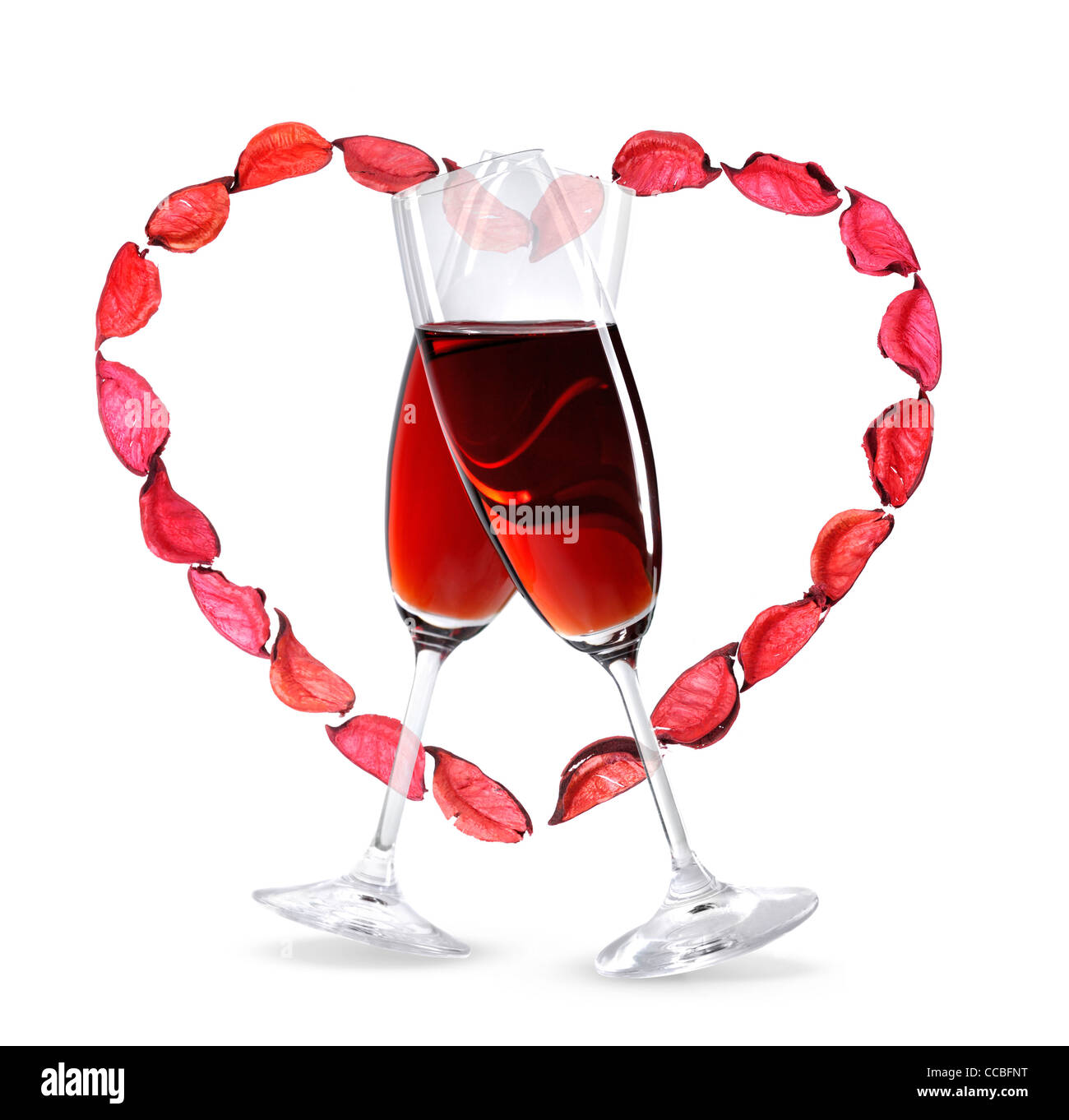 Deux wineglasses avec du vin rouge et un cœur à base de pétales de rose. Banque D'Images