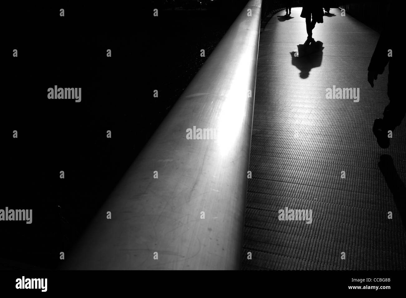 Ombres et silhouettes de piétons marchant sur la passerelle à l'ouest de l'Inde du Sud Dock, Canary Wharf, London, UK Banque D'Images