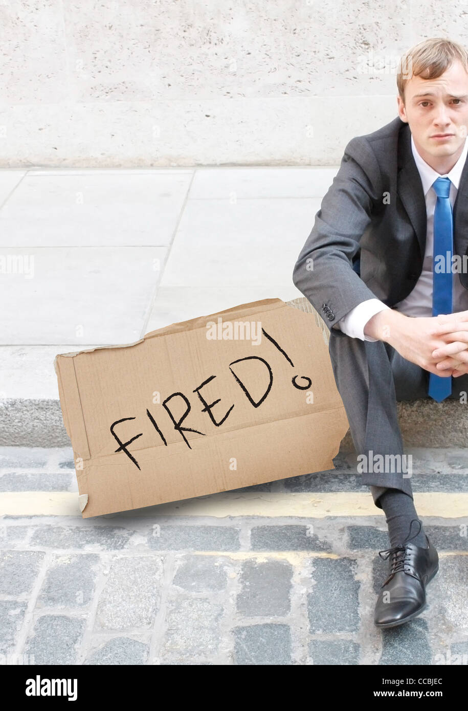 A worried business man sitting on the street Banque D'Images