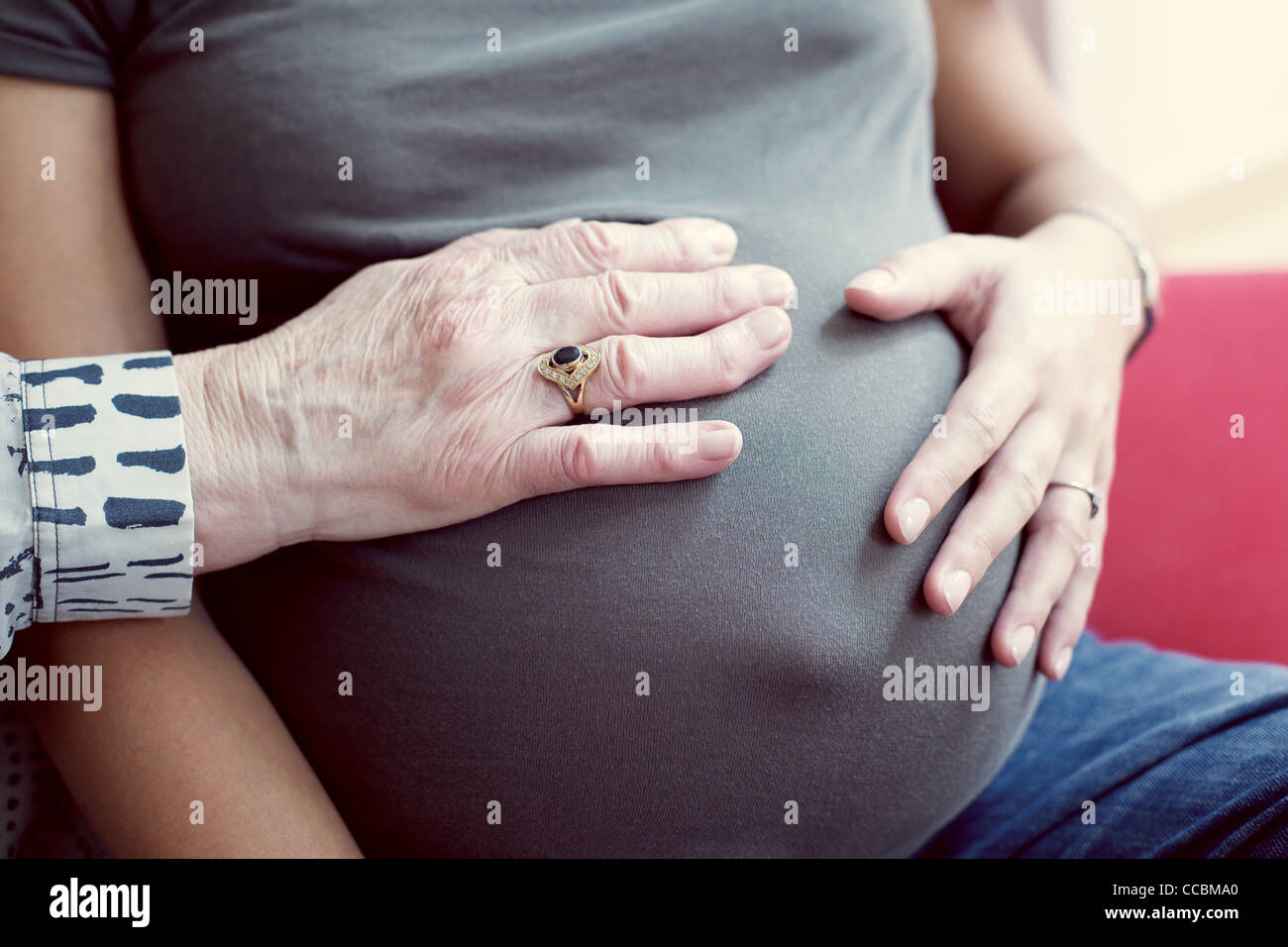 Les mains sur l'abdomen de la femme enceinte Banque D'Images