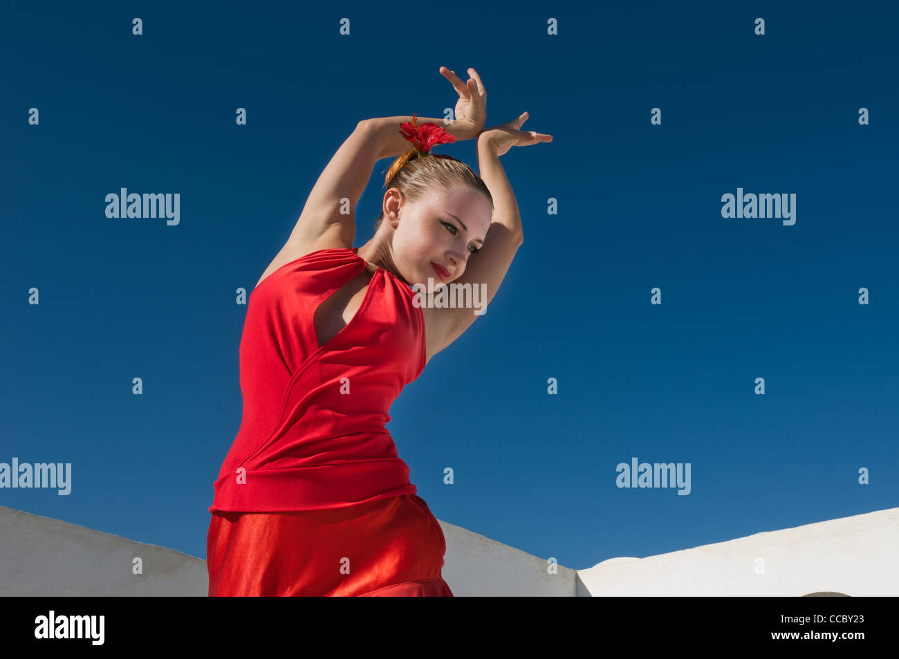 Danseuse de flamenco traditionnel attrayant portant robe rouge avec une fleur dans ses cheveux Banque D'Images