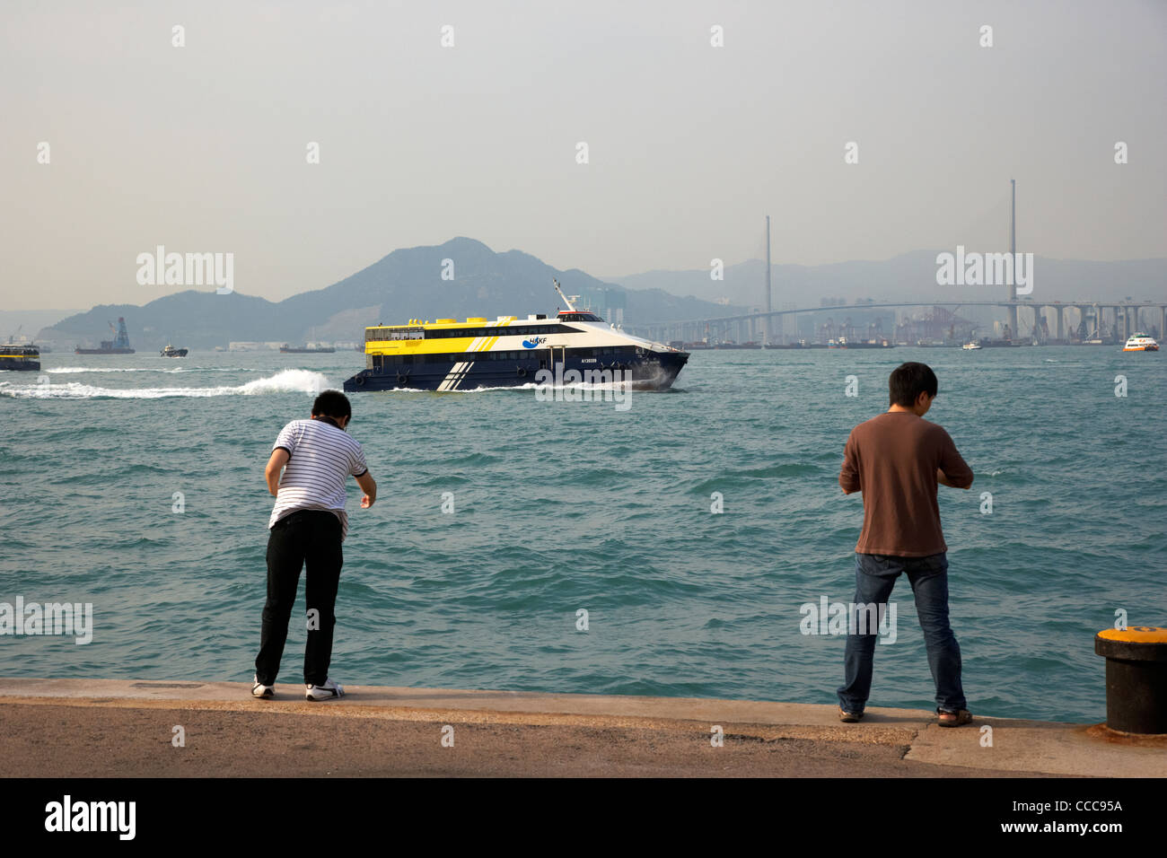 Hong Kong Kowloon ferries ferry sereine de la mer la pêche sur les hommes passe petit embarcadère port victoria western district hong kong hong kong Banque D'Images