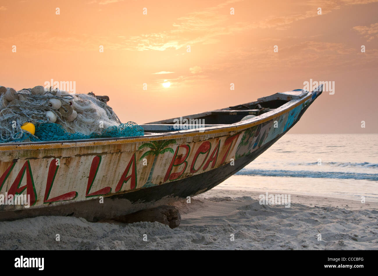 Bateau de pêche gambienne sur plage de Kololi au coucher du soleil, près de Banjul, Gambie, en Afrique de l'Ouest Banque D'Images
