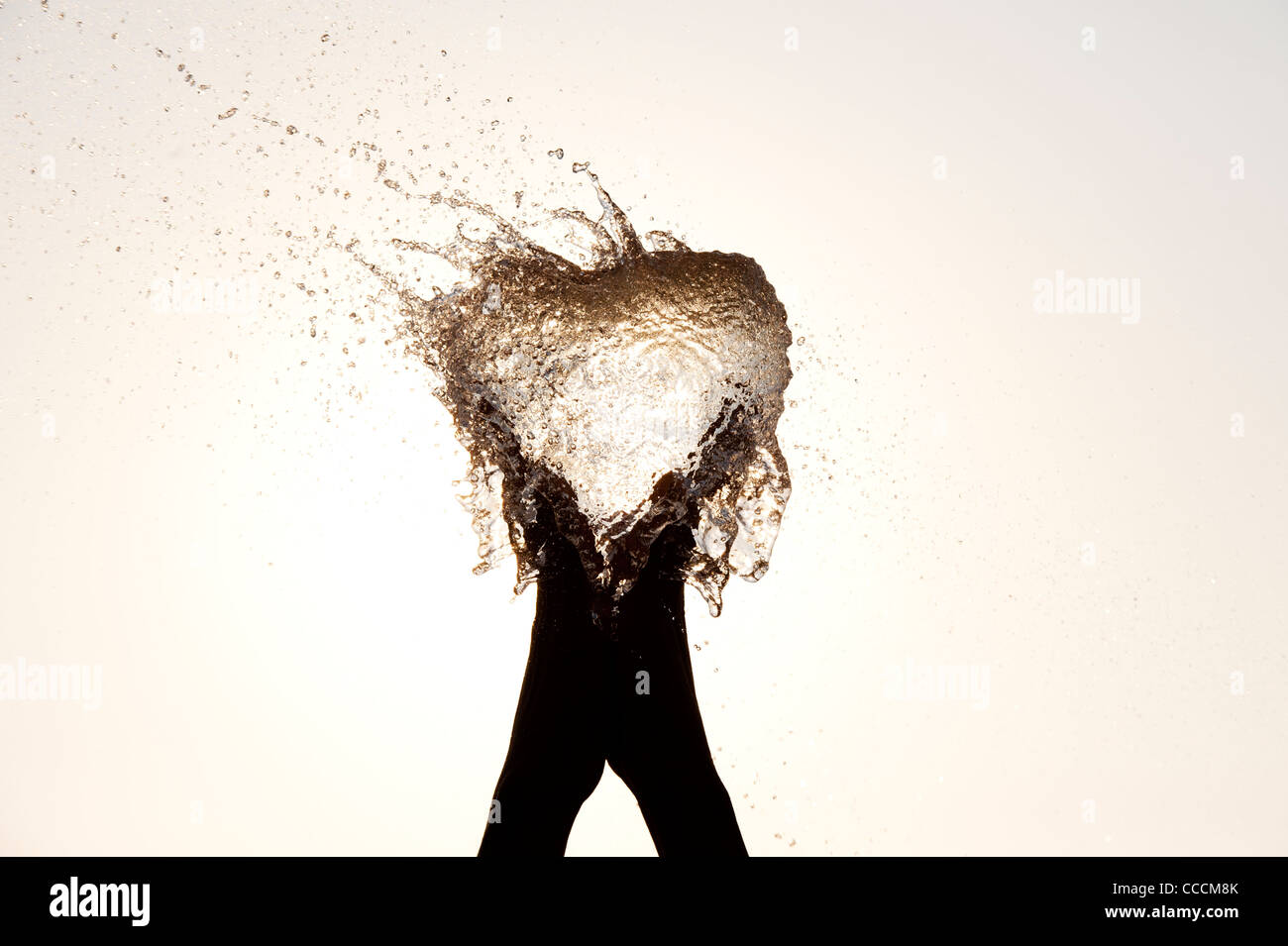 Les filles indiennes hands holding a water balloon burst Banque D'Images