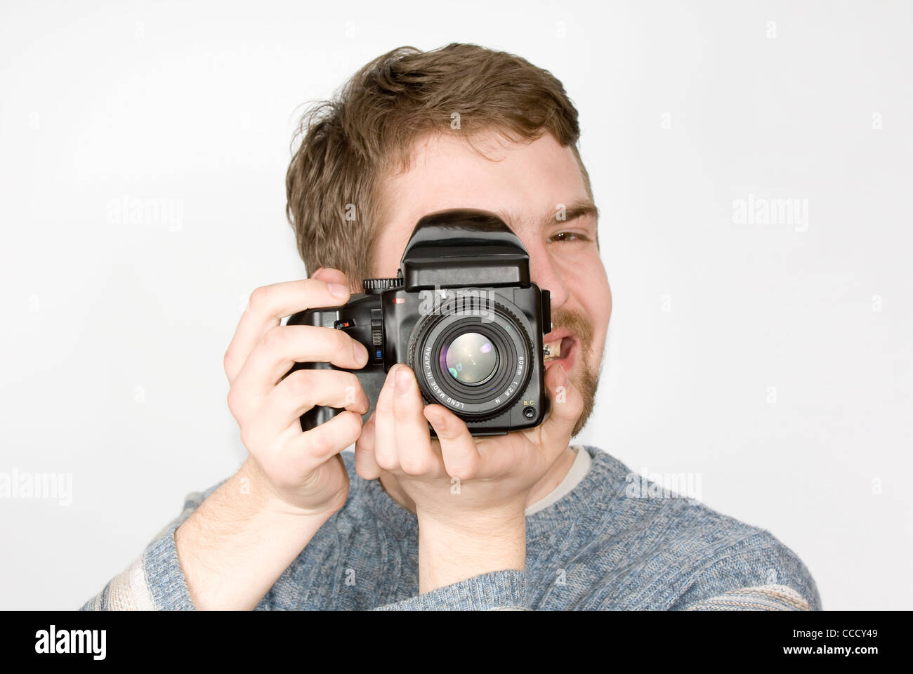 Young cheerful photographe avec appareil moyen format shot against white background Banque D'Images