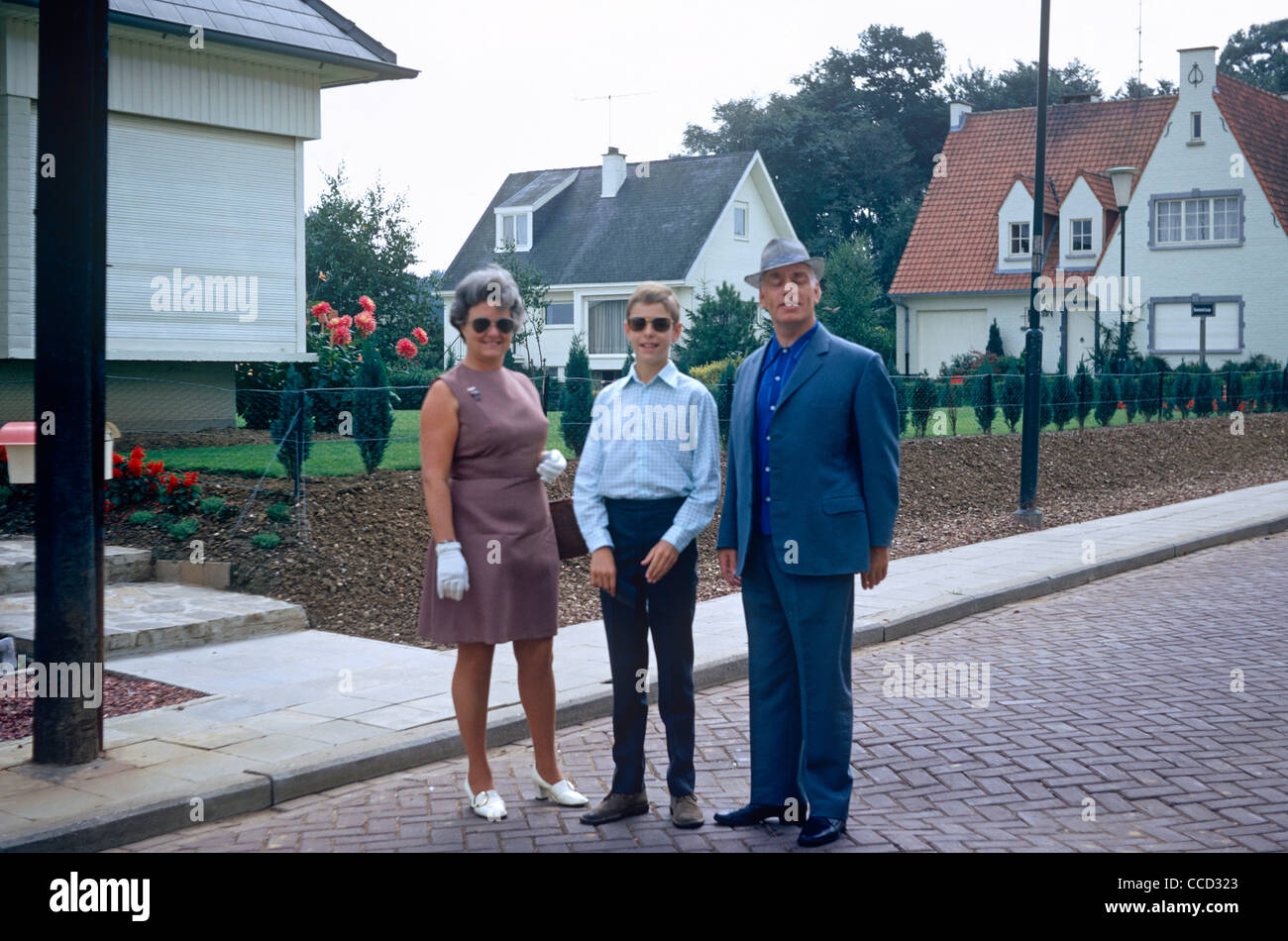 Un moyen-âge mère et père d'un fils adolescent posent pour une photo à l'extérieur de leur maison dans une banlieue belge au début des années 70. Banque D'Images