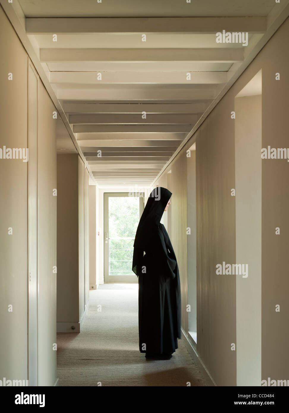 Stanbrook abbey par Feilden Clegg Bradley studios, corridor de cellules à fin fenêtre avec nun Banque D'Images