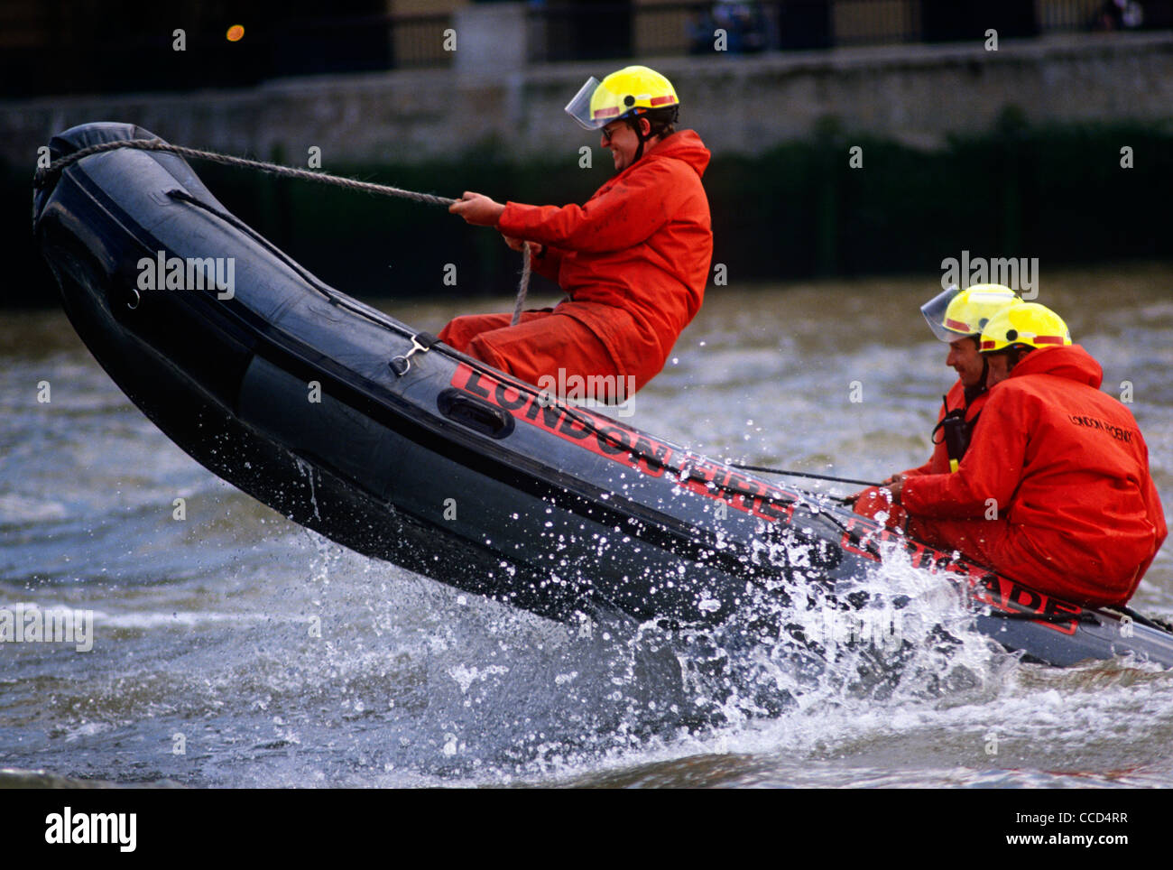 Sautant par-dessus les vagues, London Fire Brigade (BF) les pompiers s'entraînent sur la Tamise à l'aide d'un canot pneumatique Banque D'Images