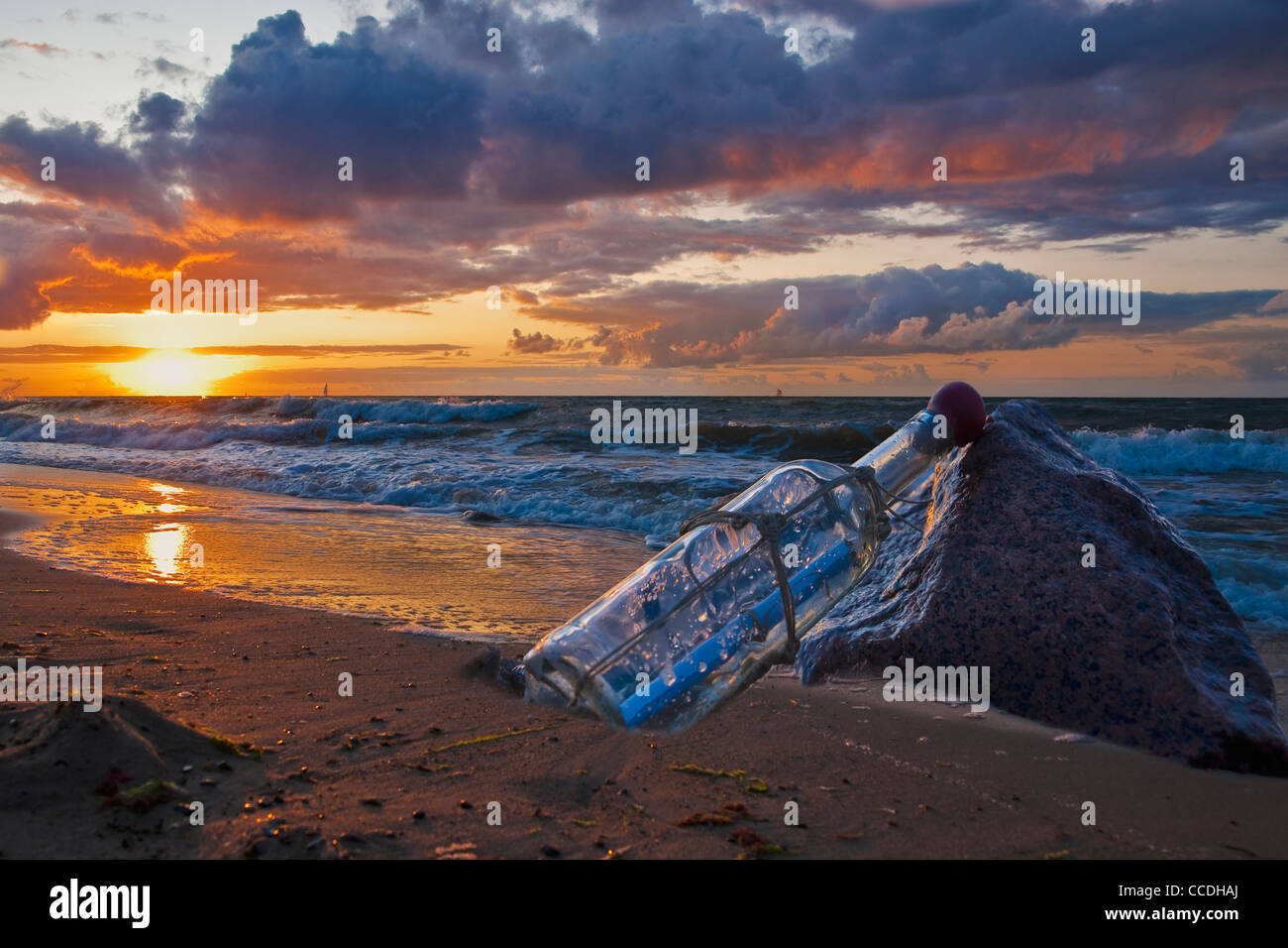 Photo détail d'un message dans une bouteille, se penchant sur une pierre au bord de la mer Banque D'Images