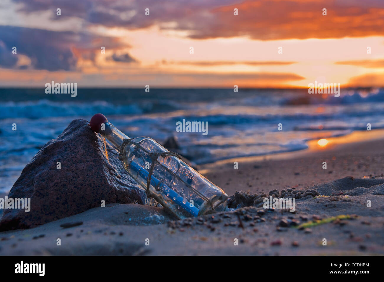 Photo détail d'un message dans une bouteille, se penchant sur une pierre au bord de la mer Banque D'Images