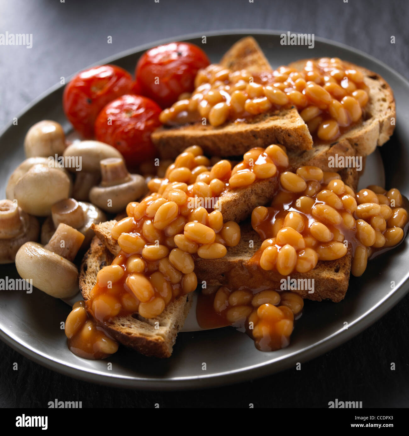 Petit-déjeuner sain, les haricots sur toast, tomates et champignons Banque D'Images