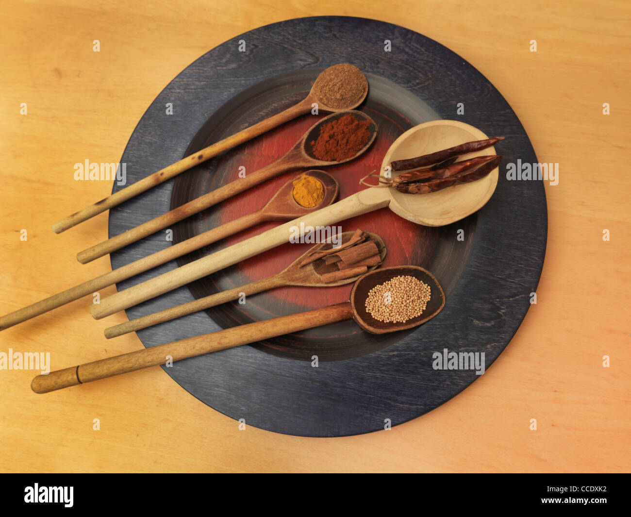 Collection d'épices sur des cuillères en bois sur une plaque Caram Masala, Paprika fumé, le curcuma, le piment, la cannelle et les graines de moutarde Banque D'Images