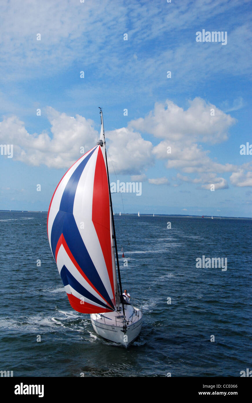 Bateau à voile avec bleu,rouge,voile blanche Banque D'Images