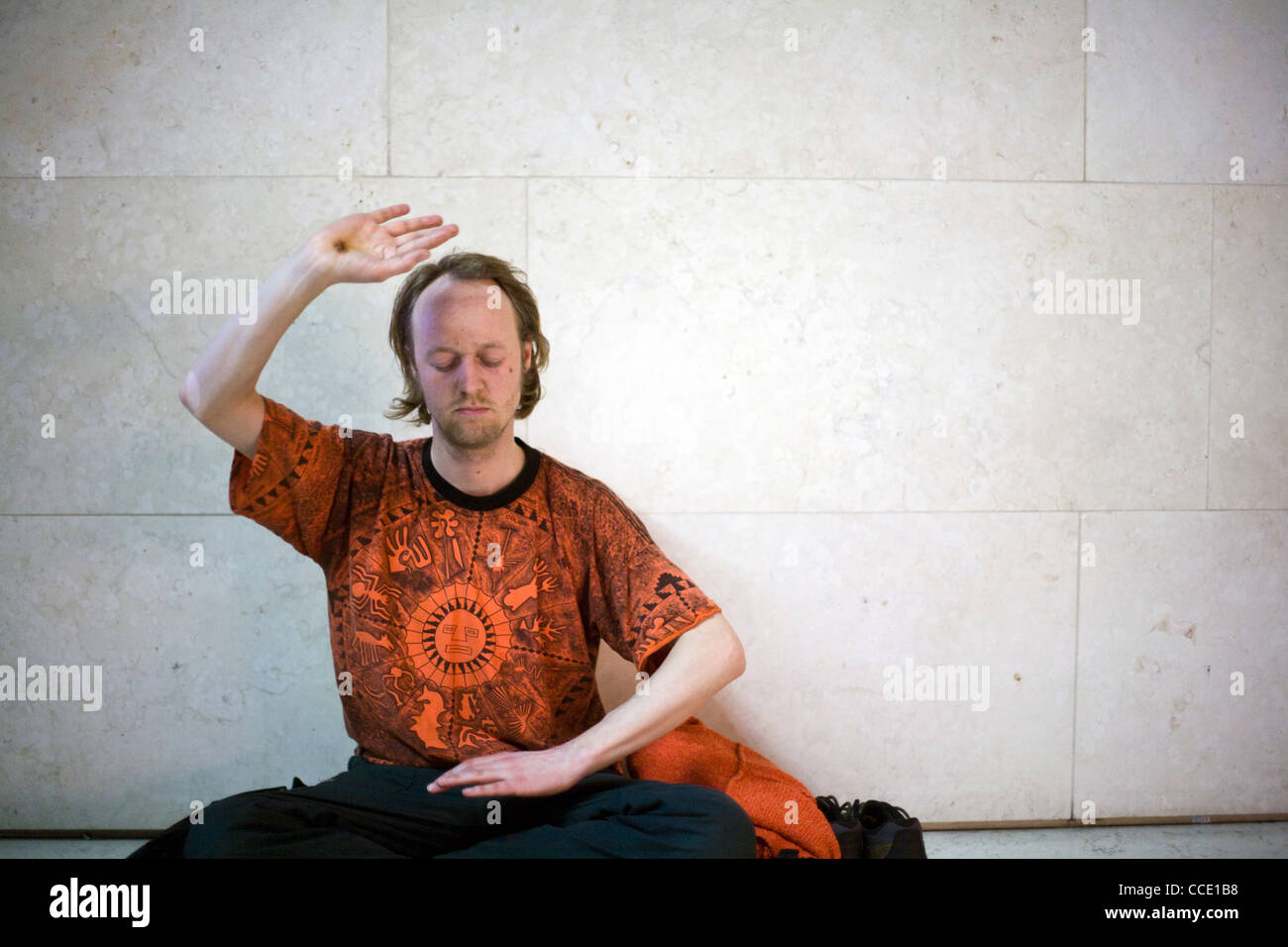 Un homme effectue des exercices de qi gong dans le cadre d'une méditation flash mob dans la grande cour du British Museum Banque D'Images