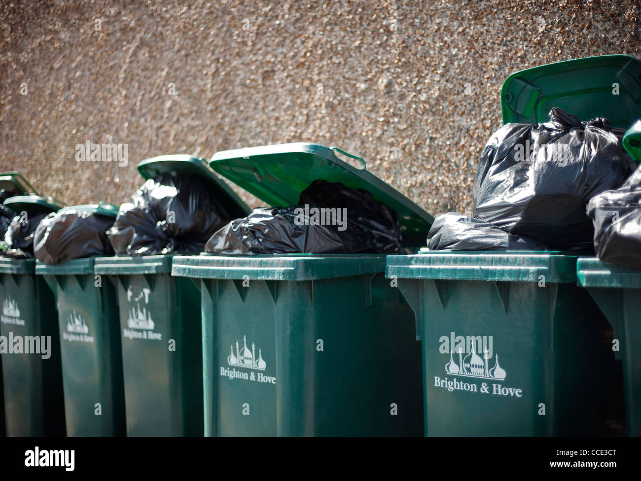 La débordante wheelie bins contre un mur à Brighton et Hove, Royaume