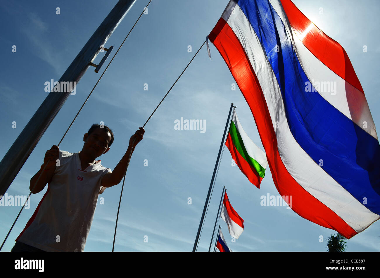 Un homme soulève des drapeaux du Riverside à Phnom Penh, Cambodge Banque D'Images